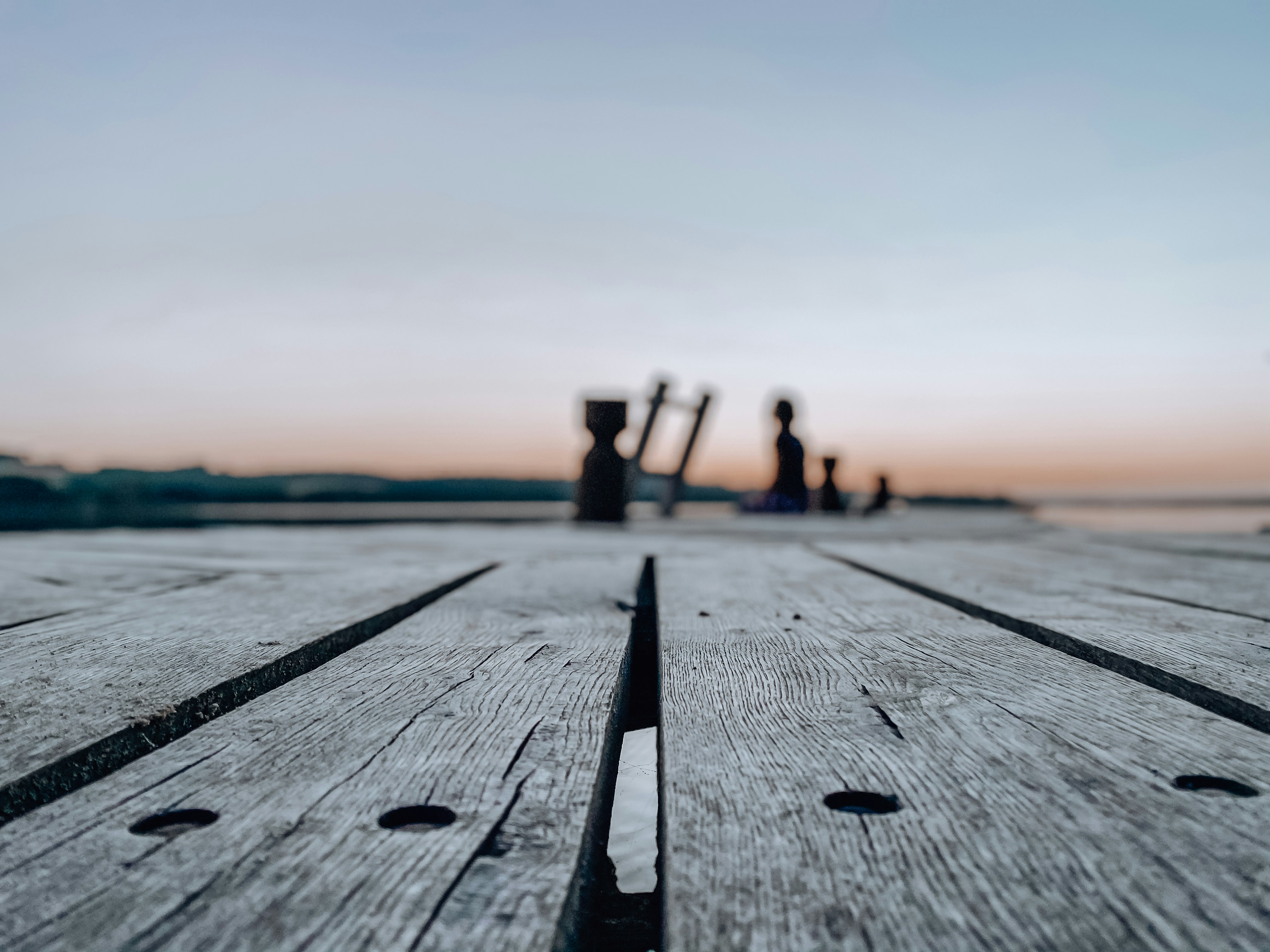 people walking on wooden dock during sunset
